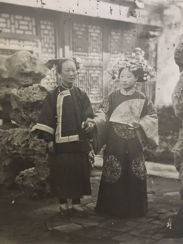 在摄影师努力的沟通下,    满族姑娘跟旁边的女佣人    摆拍了这张