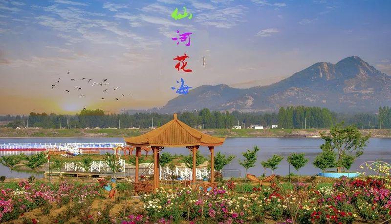 风景宜人,两岸鲜花芬芳,临水而建的休闲小木屋舒适惬意,抬眼便观青山