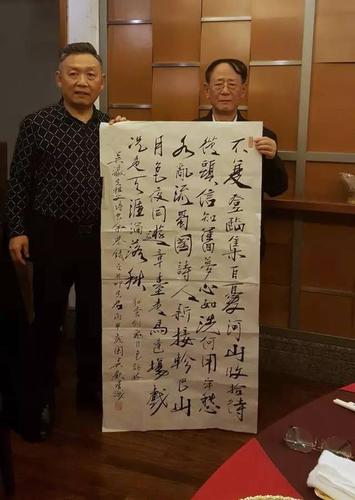 吴欢向胡德平赠送亲笔创作的书法作品.