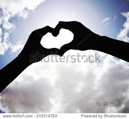 two hands making a heart shape in the sky toned with a vintage