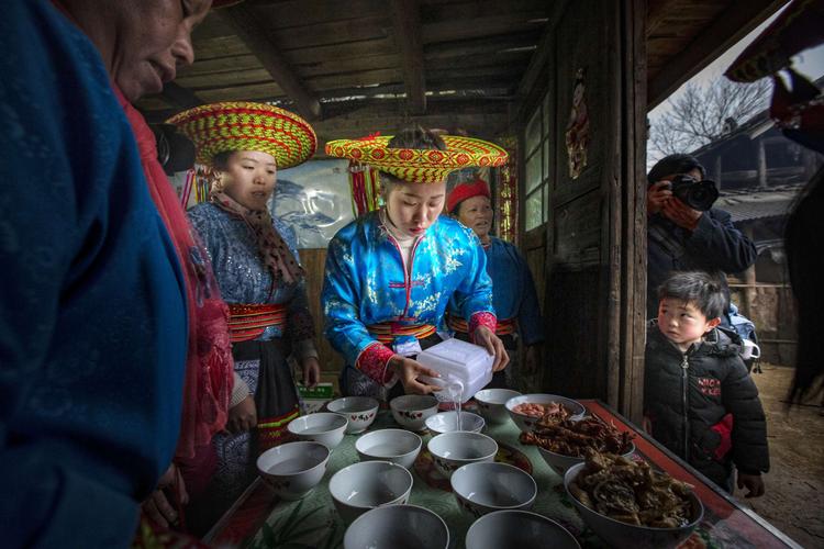 在女方家中,已经按照传统习俗,摆上了拦门酒,几位大嫂在门口等候着
