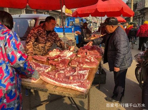 顾客在卖肉摊位前买肉.