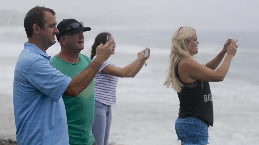 people take photos of the sea in los cabos, mexico, on sunday