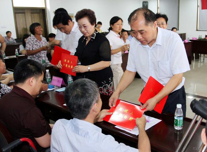省财政厅副厅长黄晓平为残疾人及其亲友代表发放残疾人护理补贴