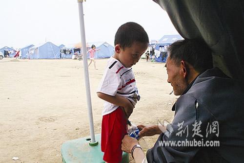 图为:蒋玉乐用瓶子给小孙子接尿