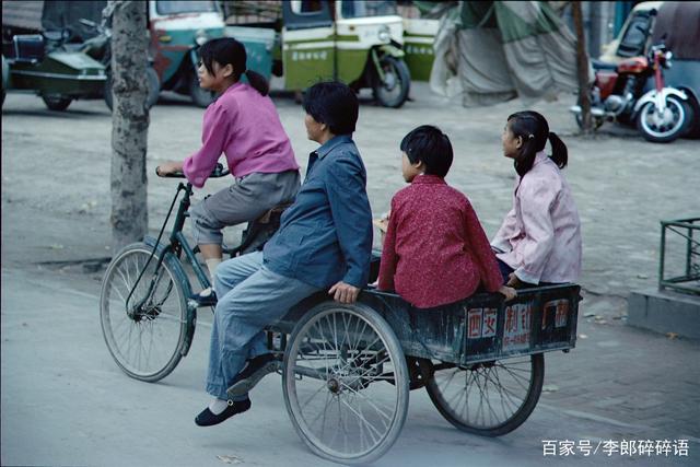 1980年代的西安街景,一辆三轮车载着一家四口人.
