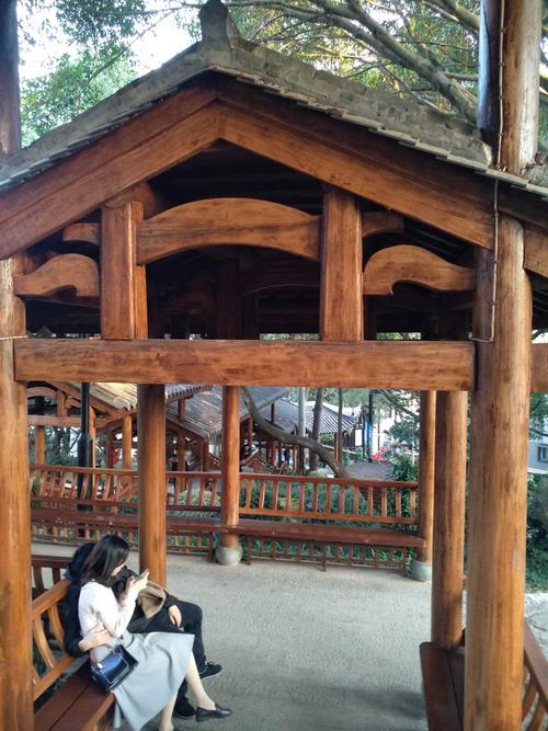 一对小情侣正紧紧地依偎在一起,边看手机边絮絮叨叨地甜言蜜语,幸福之