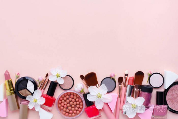 化妆刷和装饰化妆品与苹果开花在粉红色的背景柔和