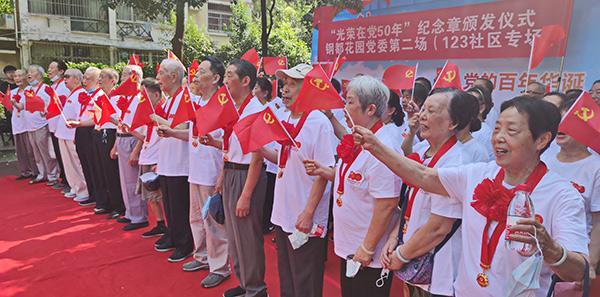 武钢老党员佩戴"光荣在党50年"纪念章 高歌庆祝建党