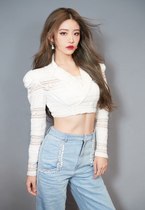 写真中喻言穿着一件白色露腰装亮相,搭配波浪卷的发型,以及低腰牛仔裤