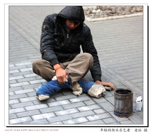 在人行道上用粉笔写诗乞讨的年轻乞丐,有点西方艺术乞丐的味道.