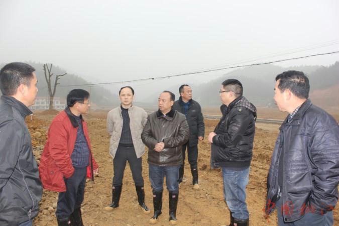 图为黄志刚在武潭镇完小新址工地了解情况