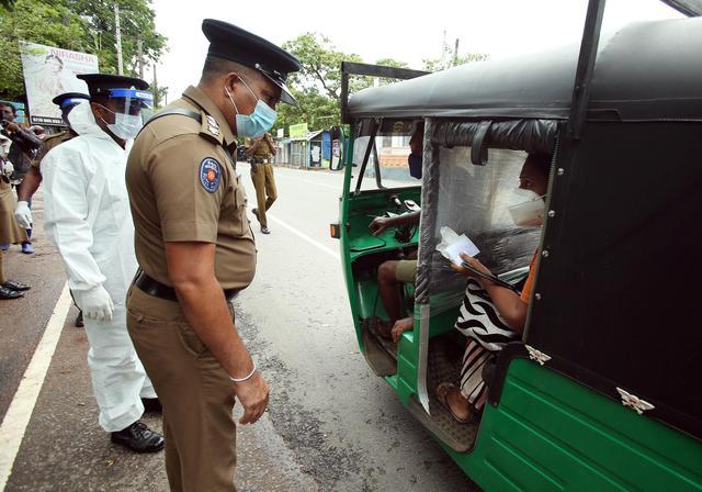 5月14日,警察在斯里兰卡科伦坡街头检查出行人员的证件.