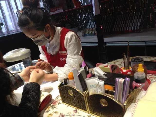 海底捞服务员给排队顾客做美甲服务