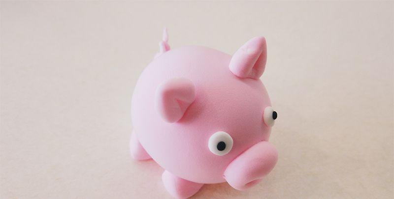 1,首先用一团粉色粘土做出小猪圆滚滚的身体,给它贴上圆圆的鼻子后,用