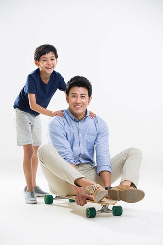 可爱的小男孩和爸爸玩滑板