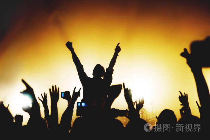 在摇滚粉丝的演唱会上表演舞台的歌手的剪影.