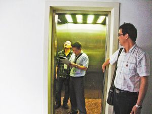 工作人员在现场检查电梯.袁青青摄