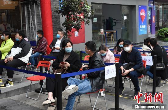 重庆部分餐厅恢复堂食供应 市民戴口罩排队吃火锅