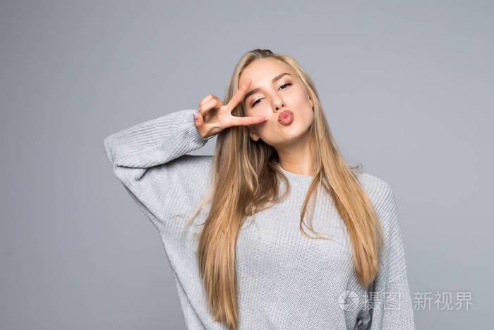 特写欢快的兴奋滑稽快乐积极乐观与牙齿微笑的女孩显示 v 符号隔离在