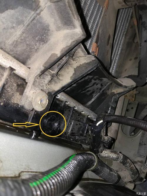 拆除护板后,躺在车底仰头向车头方向看,可以看到水箱底部塑料放水螺栓