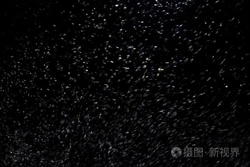 抽象的暴风雪纹理在黑色背景上的散景灯拍摄的飞片雪花在空中