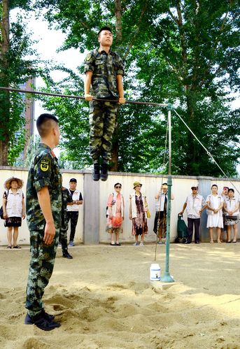 武警战士为志愿者们表演单杠.