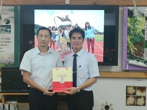 宜昌市台办副主任程国庆(左)与苗栗西湖中学校长邱世允(右)互赠礼品