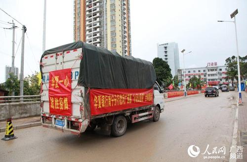 挂着"华夏一心,战胜疫情"横幅的运输物资车辆驶向院区.
