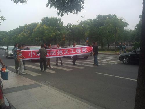 民工举横幅向小城大厨讨工程款