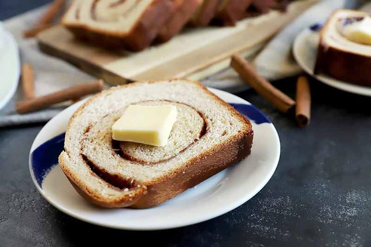 horizontal image of a slice of swirled bread on a plate next to