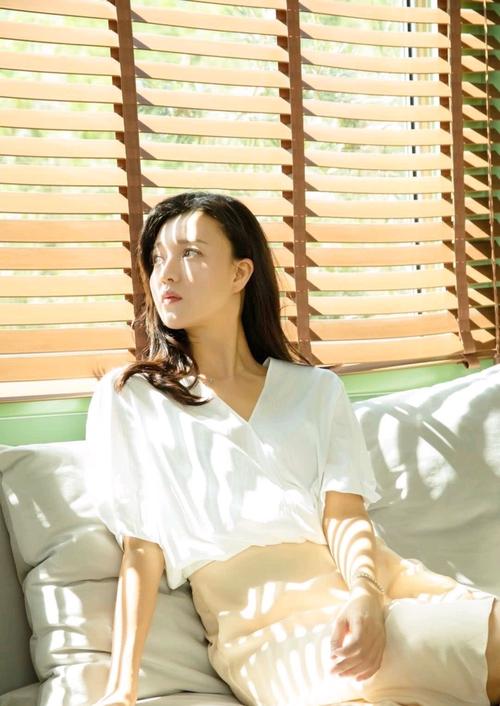 43岁傅晶的穿搭很精致,身穿白色衬衫搭配杏色半身裙,柔美又时尚