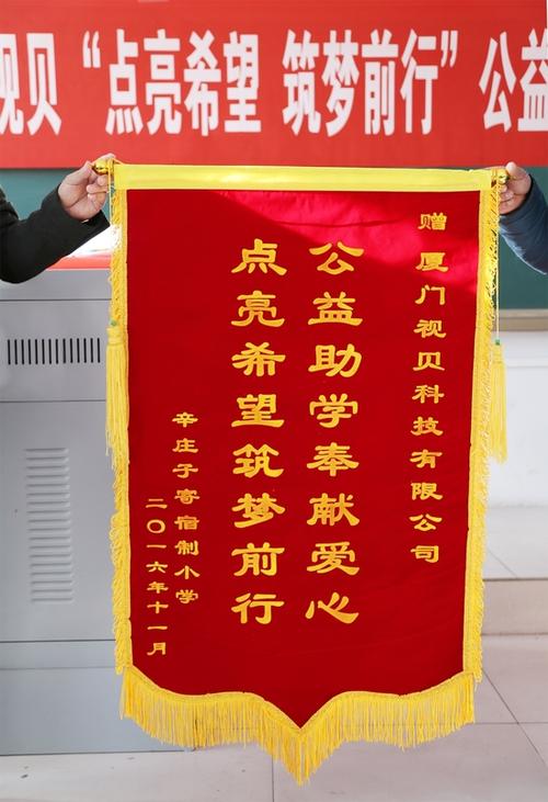部许经理赠送了一面印有"公益助学奉献爱心 点亮希望筑梦前行"的锦旗