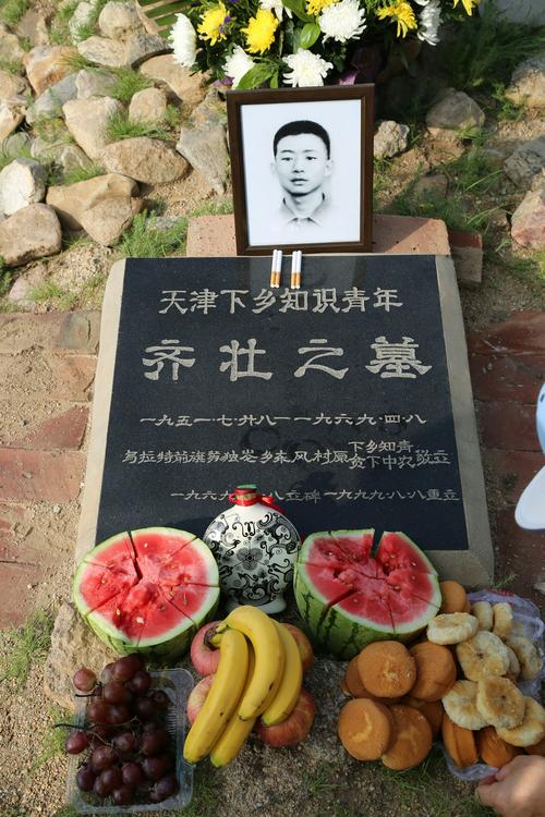 大家在齐壮墓前摆上大束的鲜花,在碑前放满香蕉,苹果,葡萄,西瓜等水果