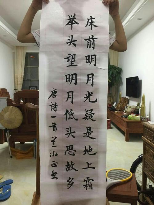 兰泓正展示他写的书法作品《静夜思》(第二稿,挂在教室用)