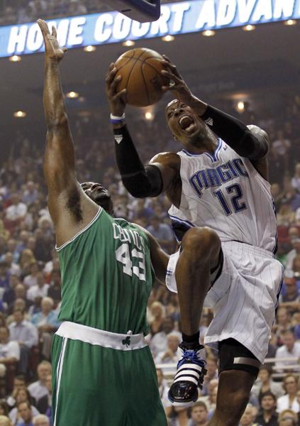 魔术队霍华德在凯尔特人队帕金斯的防守下运球上篮.图片来源:路透