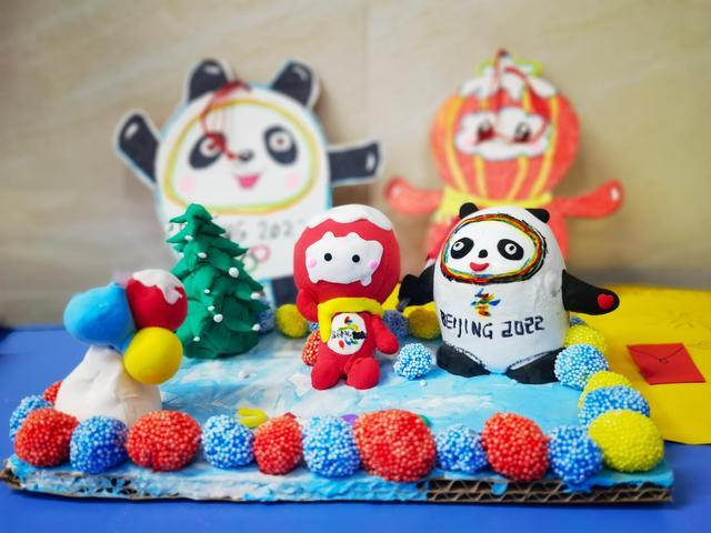 同学展示自己的"为奥运喝彩"主题活动作品,并作为寒假作业交到老师