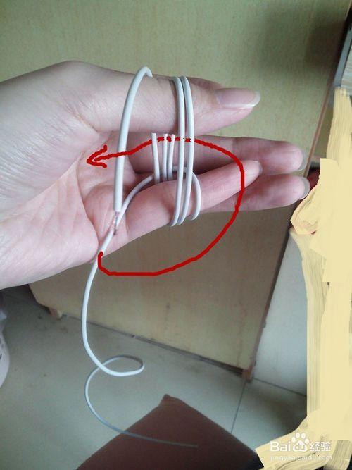 手工/爱好 > 手工艺  1 将剪下来的耳机线夹在大拇指和小拇指之间.