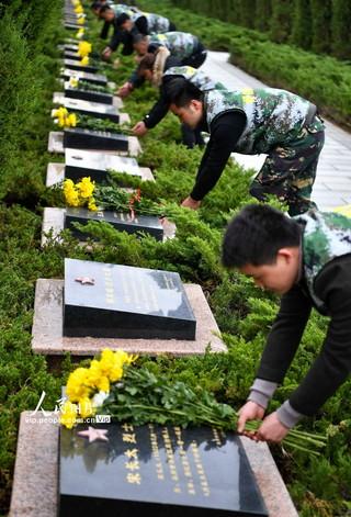 3月27日,在安徽省亳州市皖北烈士陵园,志愿者向烈士墓敬献鲜花.