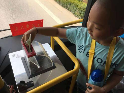 小朋友们在认真的给公交车投币.