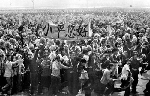 1984年10月1日,参加国庆游行的大学生通过天安门城楼时,队伍展开"小平