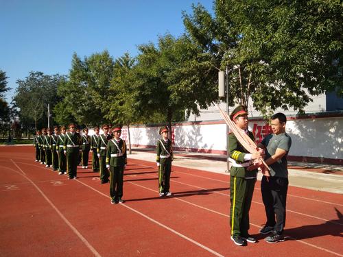 教官再给升旗手指点扛旗的姿势