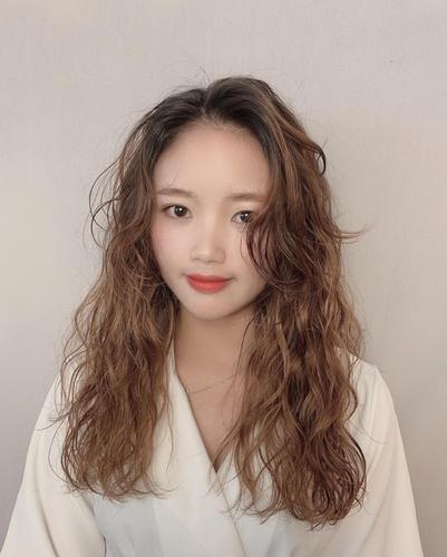 那女性选择全头烫卷卷的时候可以选择配上中分八字刘海,具有拉长显型