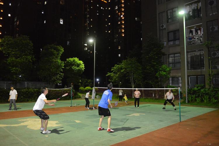 小区居民在恢复照明的高杆灯下打羽毛球.(摄影:王锋)