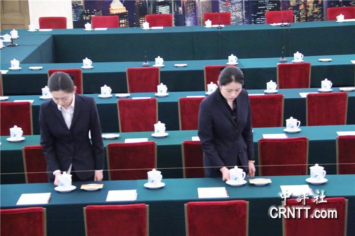 会议前,礼仪人员将茶杯摆放整齐(中评社 张心怡摄)