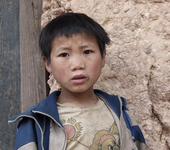 一个脏兮兮的小男孩,总是不停地跟着镜头看.摄于甘洛县挖拉洪小学.