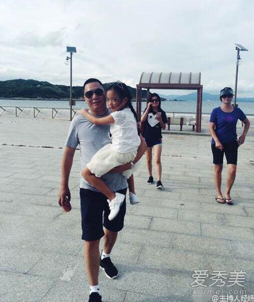 照片中,黄有龙单手抱起女儿,小四月穿着一件白色的衣服,紧搂爸爸不