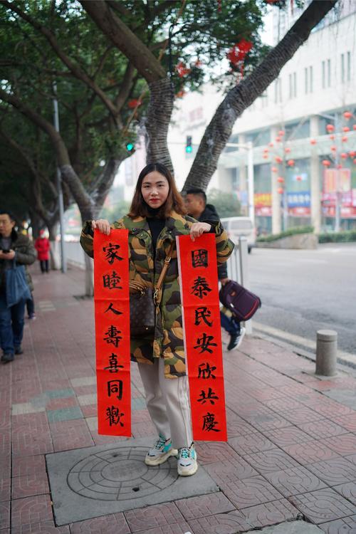 美女拿着小朋友送的春联摆拍,字美人也美!