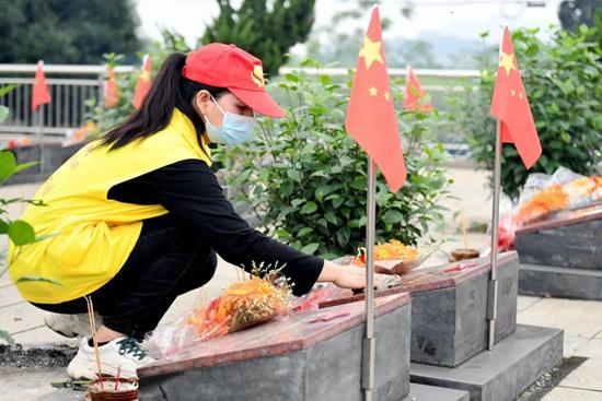 志愿者擦拭烈士墓碑