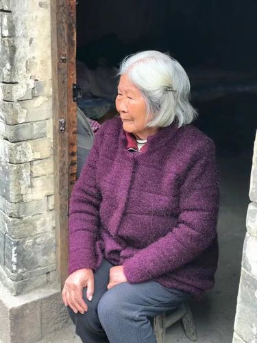 一位慈眉善目的老太太坐在屋檐下